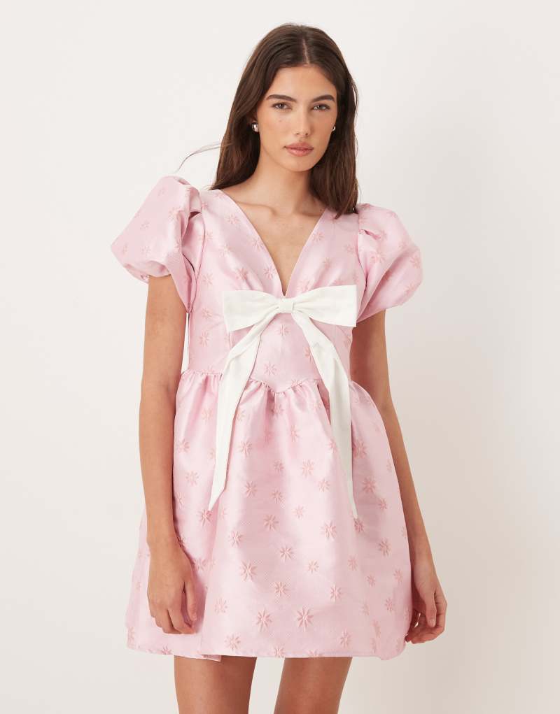 Trend V yakalı, kabarık kollu, fiyonklu pembe mini elbise.